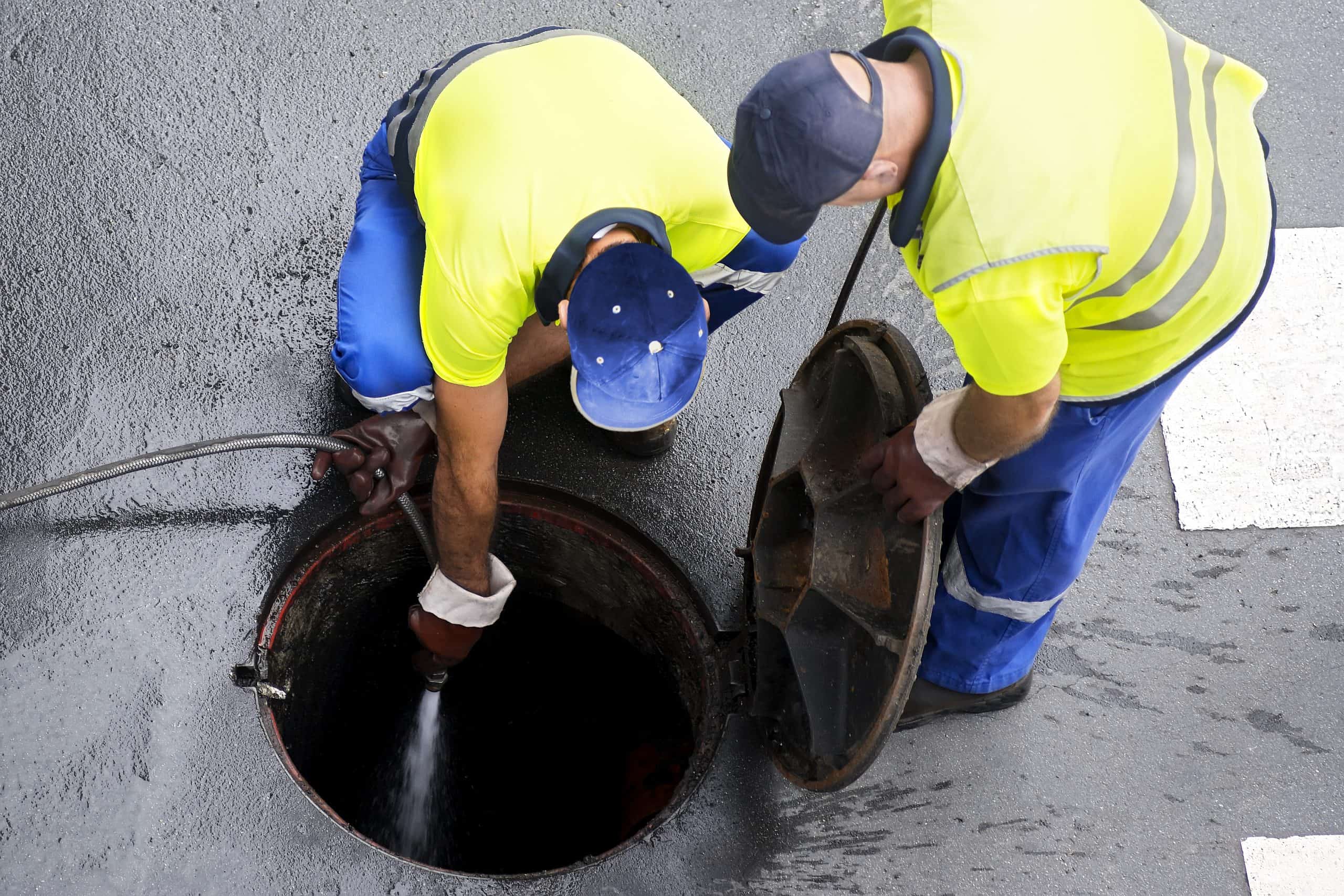 Hydro-jetting drain cleaning by professionals using high-pressure water to clear blockages.